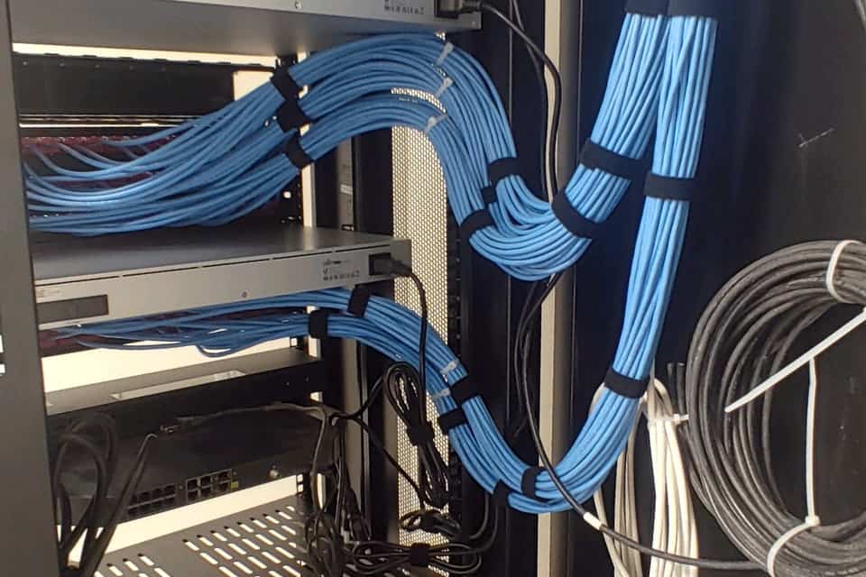 Structured cabling entering a wall mounted equipment rack.